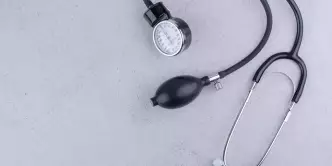 Medidor de pressão arterial e estetoscópio na superfície de mármore.