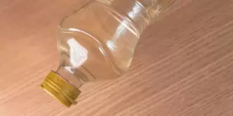 garrafa de vinagra branco em uma mesa de madeira